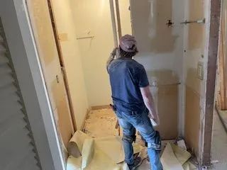A man is standing in a room with a saw.