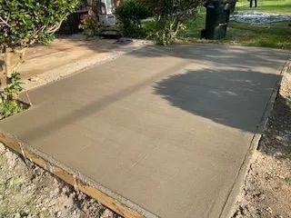 A concrete driveway is being built in front of a house.