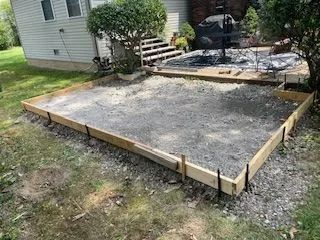 A concrete slab is being built in front of a house.