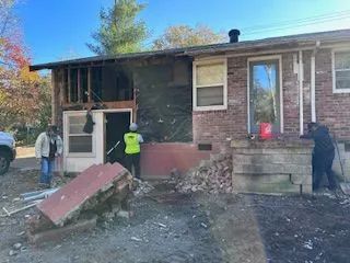 A group of people are working on a brick house.