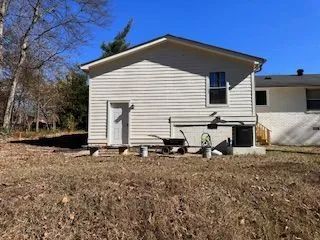 A white house is sitting on top of a dry grass field.
