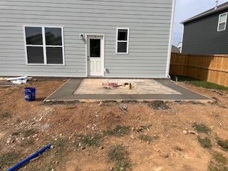 A concrete patio is being built in front of a house.