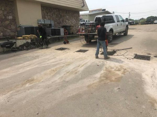 A man is standing next to a truck in a parking lot.
