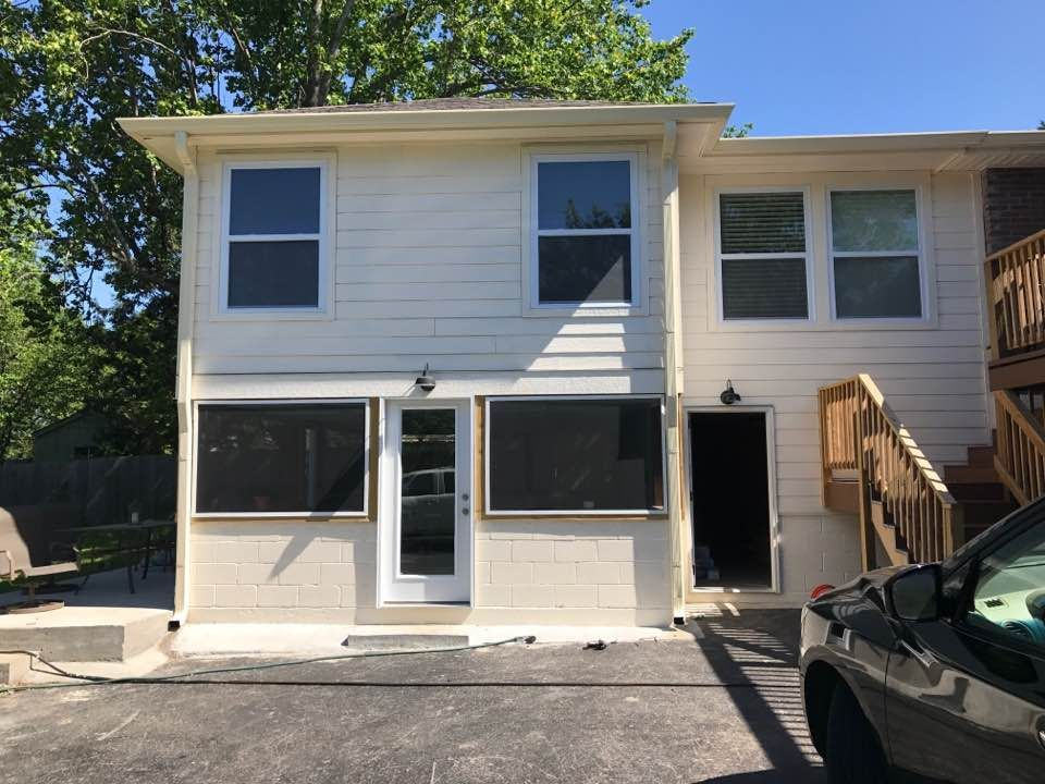 A white house with a car parked in front of it