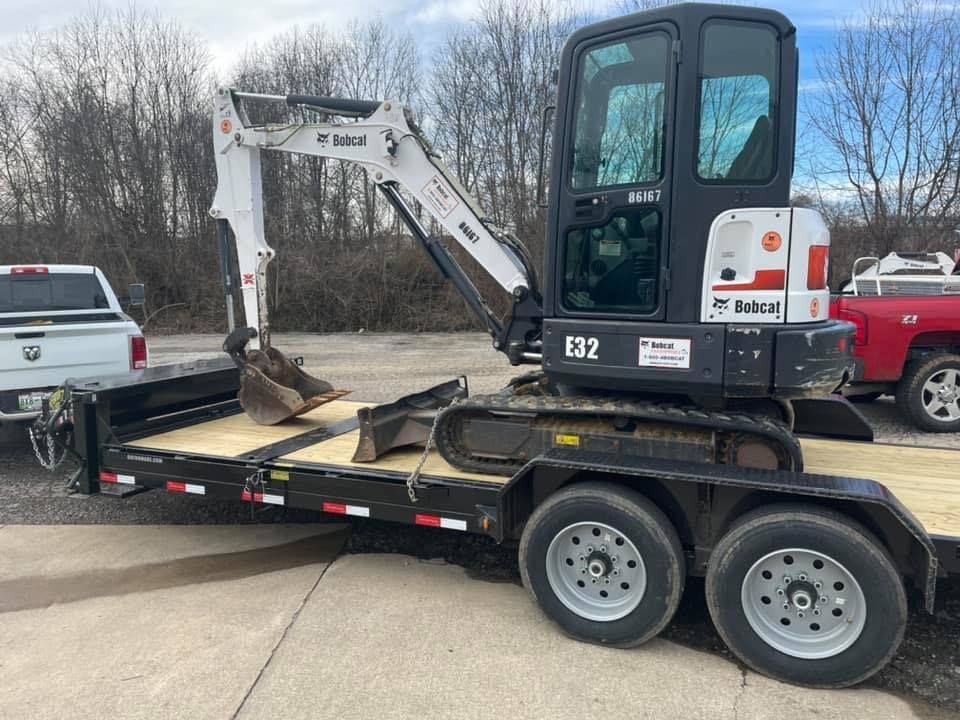 A bobcat excavator is sitting on top of a trailer.