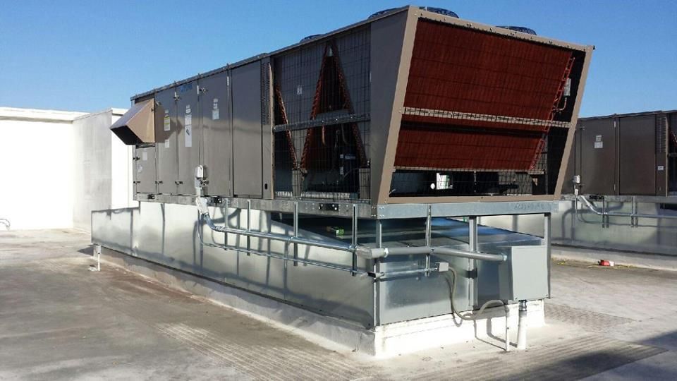 A large air conditioner is sitting on top of a roof.
