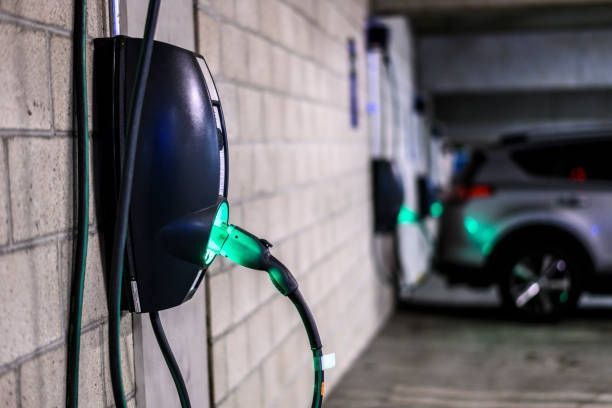 A car is being charged at a charging station in a garage.