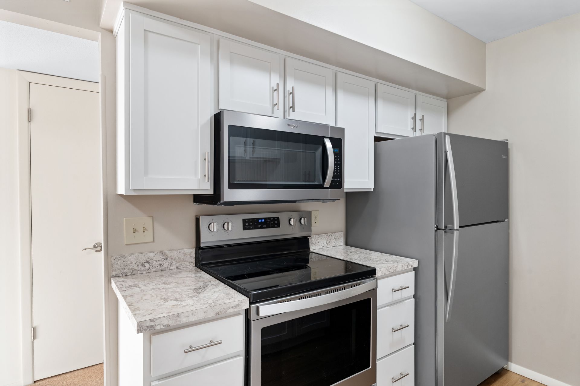Kitchen with white cabinets, stainless steel appliances, and granite countertops.
