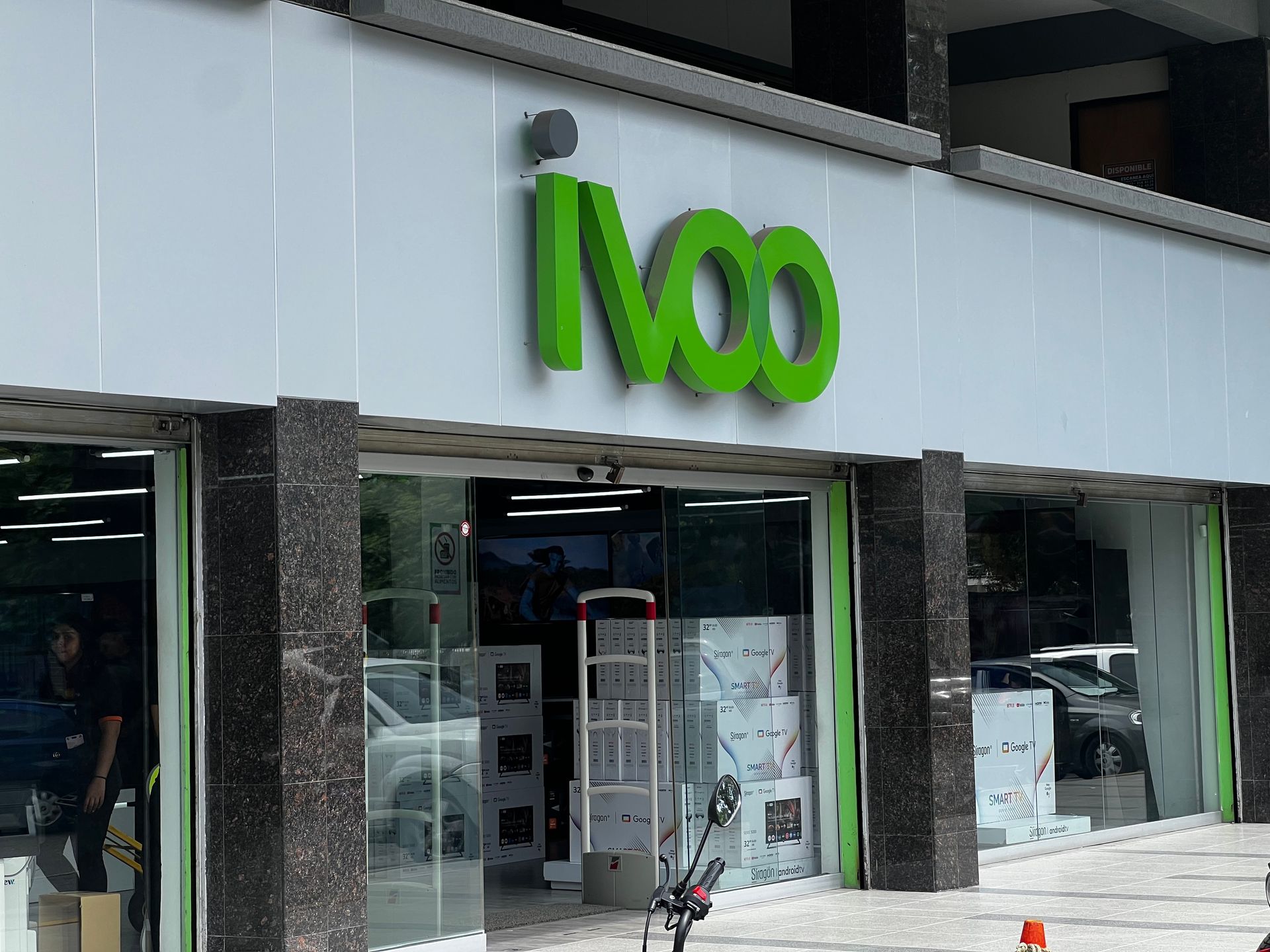 Un escaparate con un cartel verde que dice ivoo