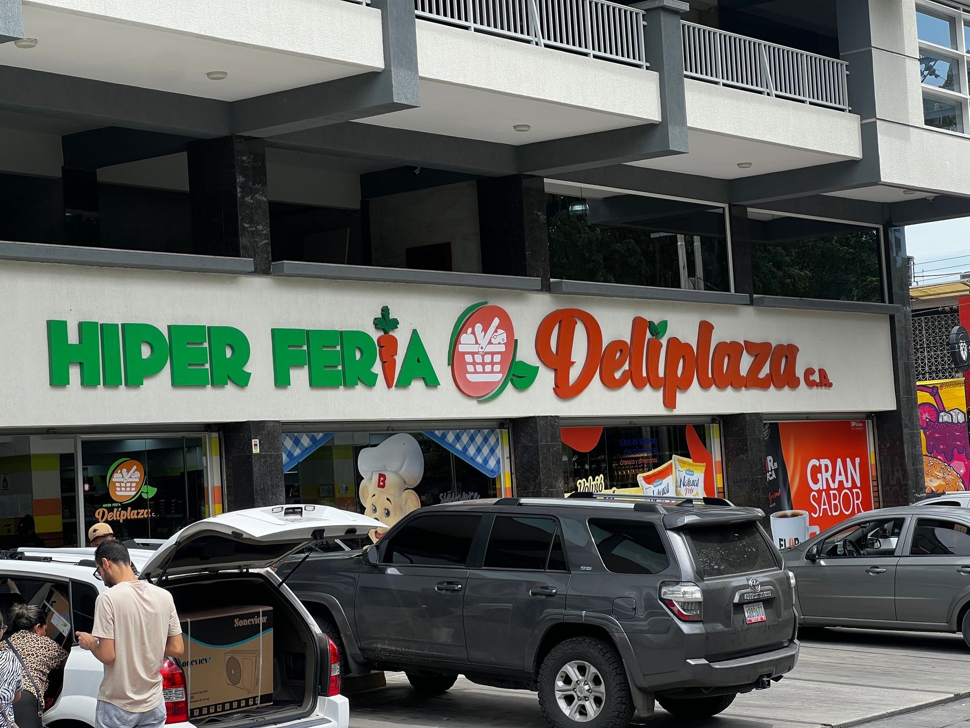 Los autos están estacionados frente a una tienda llamada hiper feria deliplaza