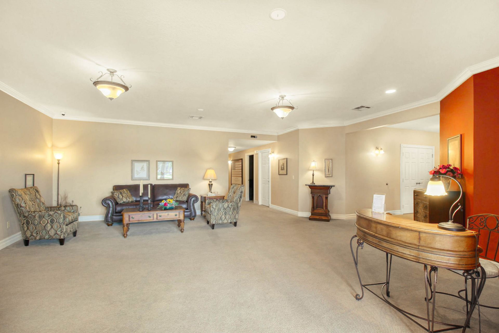 Spacious reception area with seating, a desk, and a red accent wall.