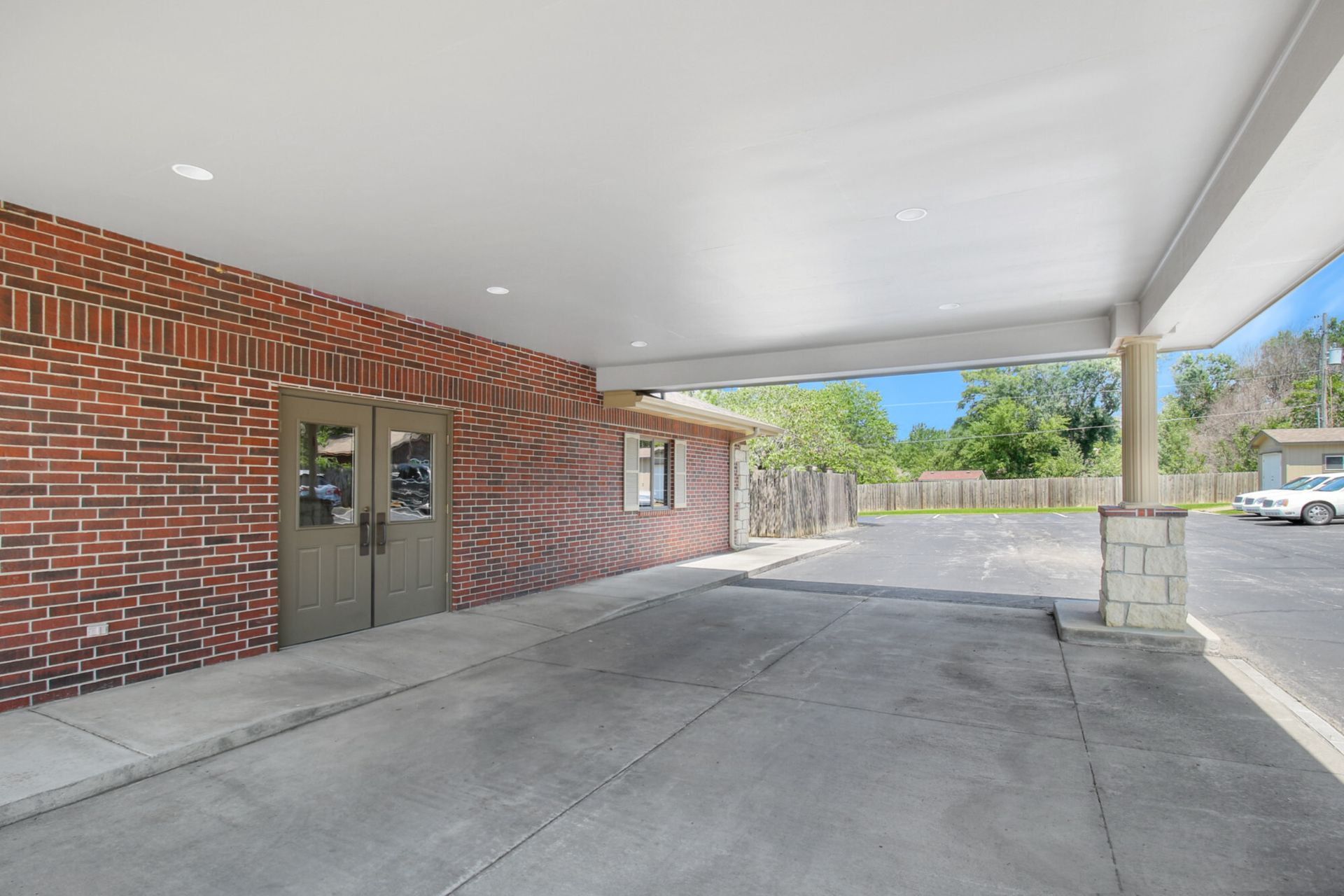 Red brick building with covered entrance and parking area.
