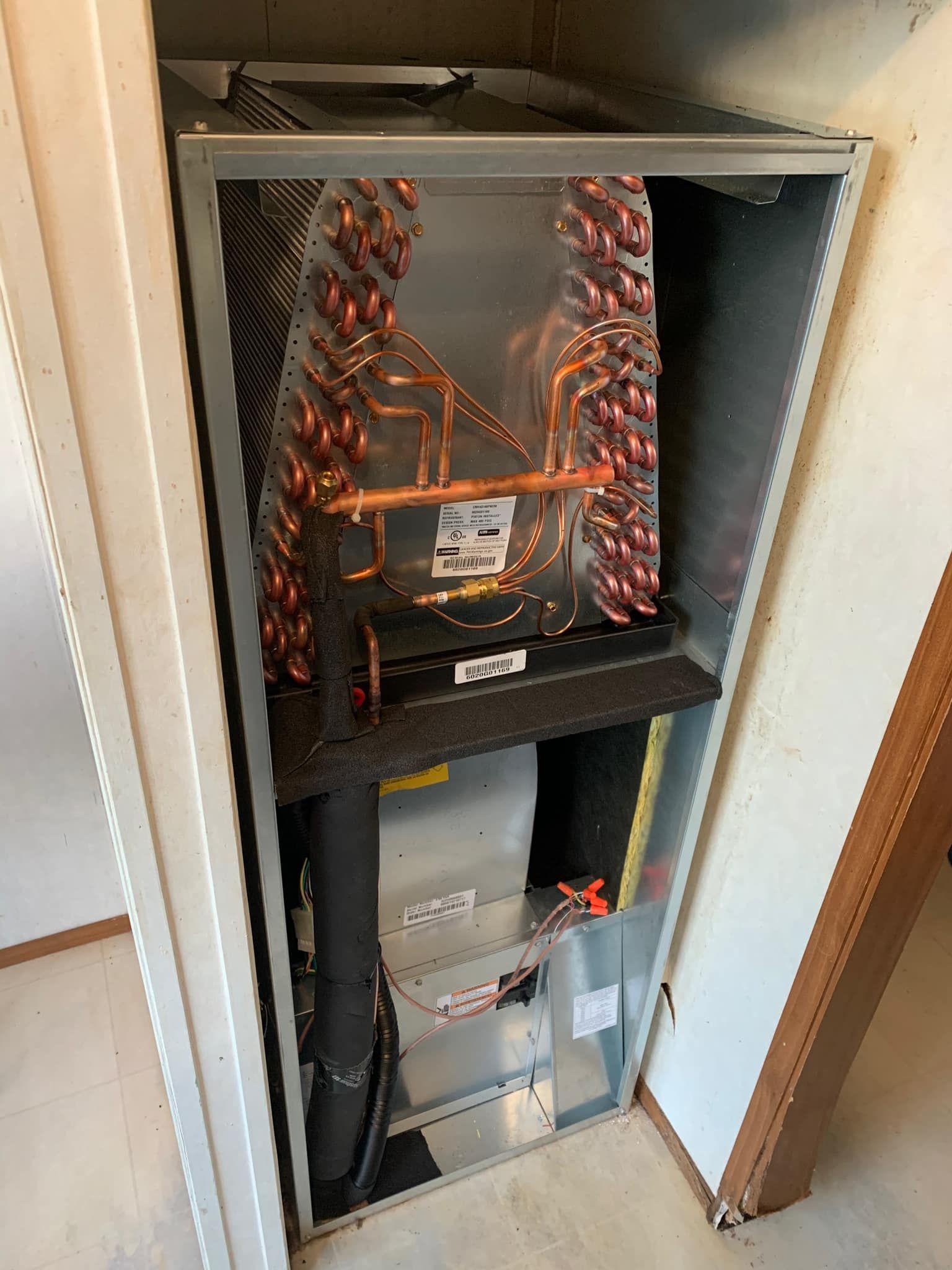 An air conditioner is sitting inside of a closet.