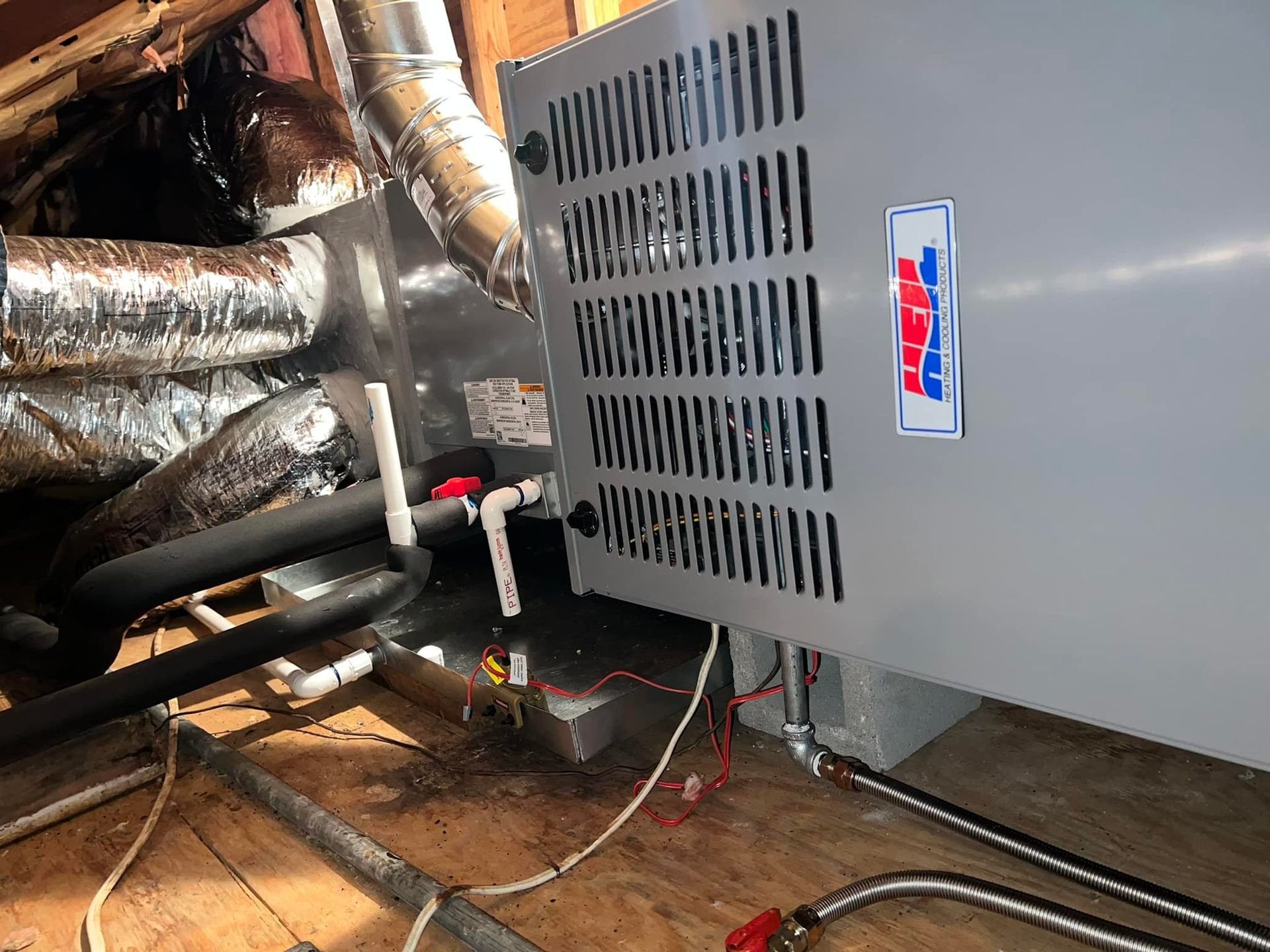 A heater is sitting on a wooden floor in a room.