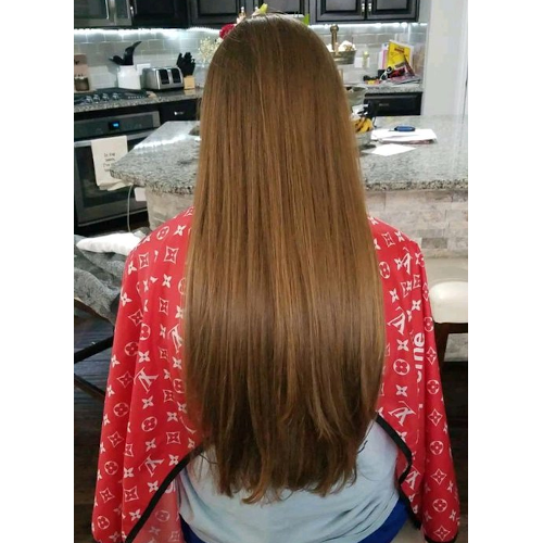 A woman with long hair is wearing a red louis vuitton cape.