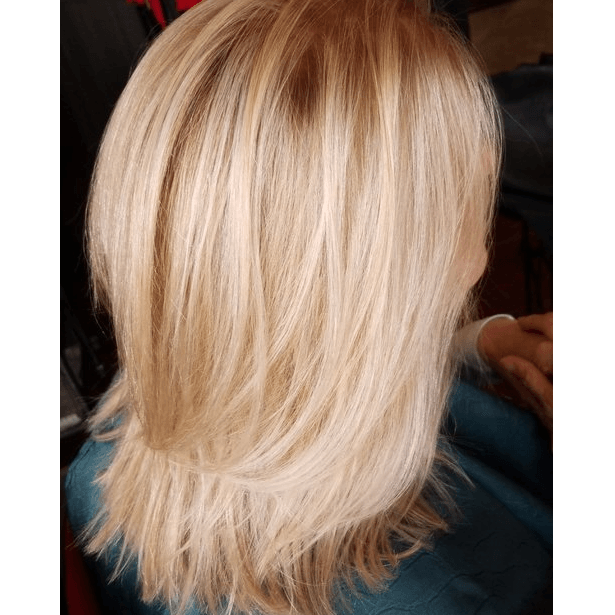 A woman with blonde hair is sitting in a chair.