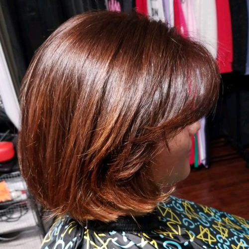 A woman is getting her hair cut in a salon.