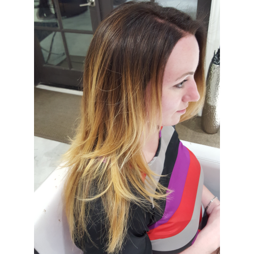 A woman with long blonde hair is sitting in a chair