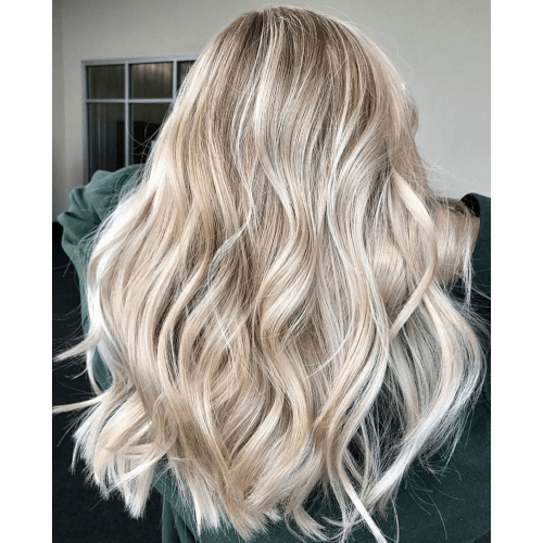 A woman with long blonde hair is wearing a green sweatshirt.