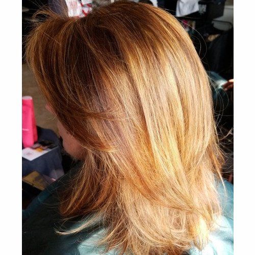 A woman with long blonde hair is sitting in a chair.