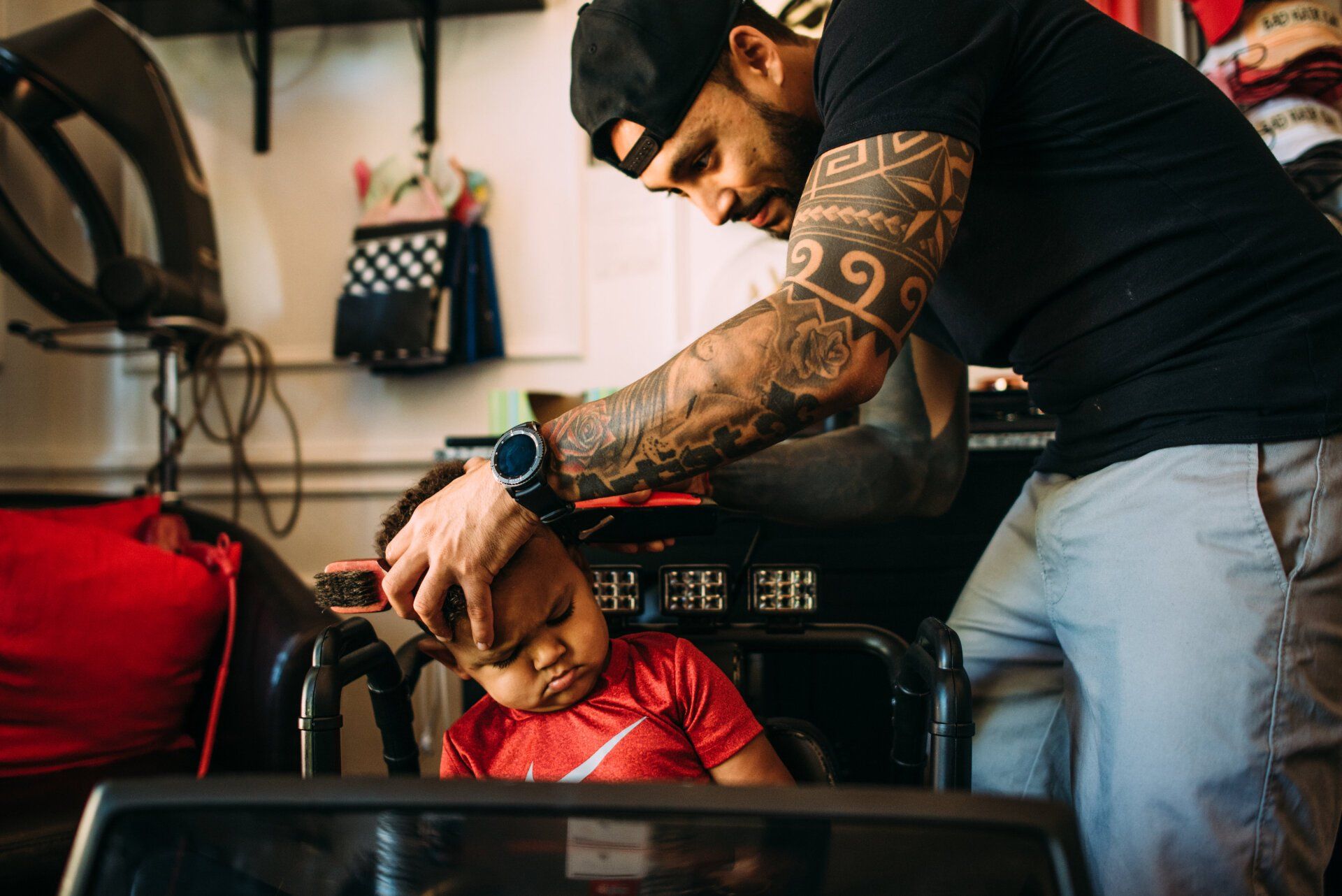 A man is cutting a child 's hair in a salon.