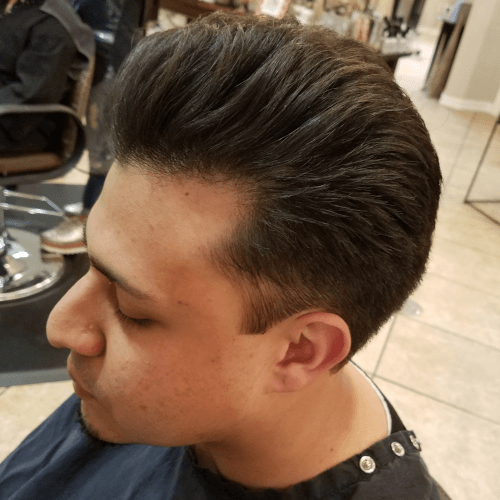 A man is getting his hair cut at a barber shop
