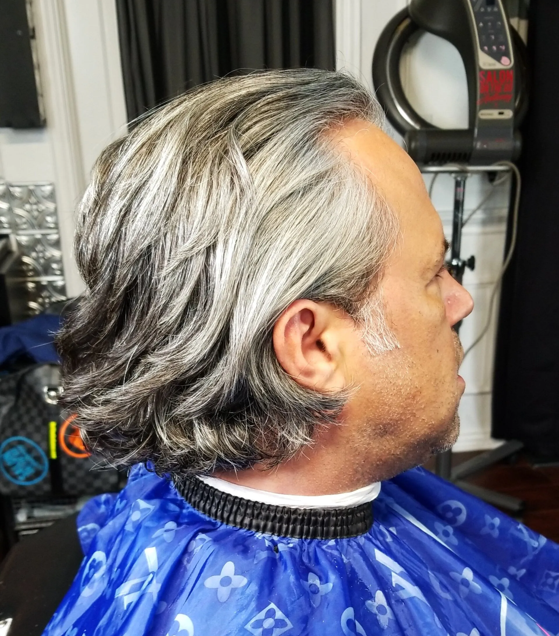 A man is getting his hair cut at a barber shop
