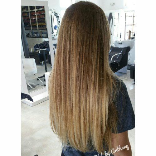 A woman with long hair is standing in a salon.