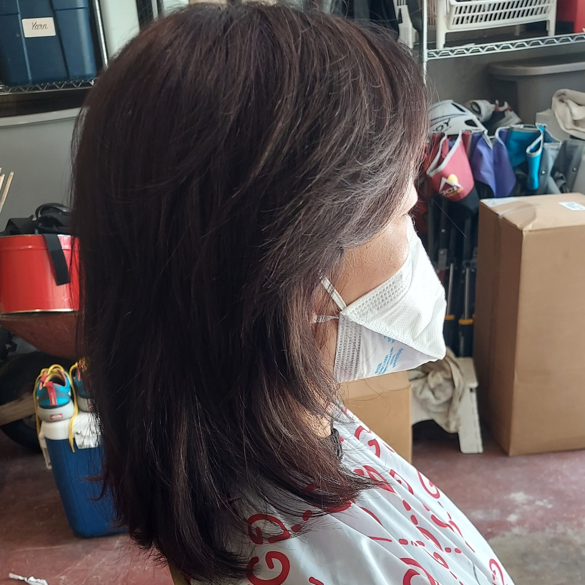 A woman wearing a face mask in a garage