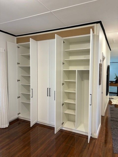 A Room With a Lot of White Cabinets and Shelves — Cairns Custom Wardrobes in Manunda, QLD