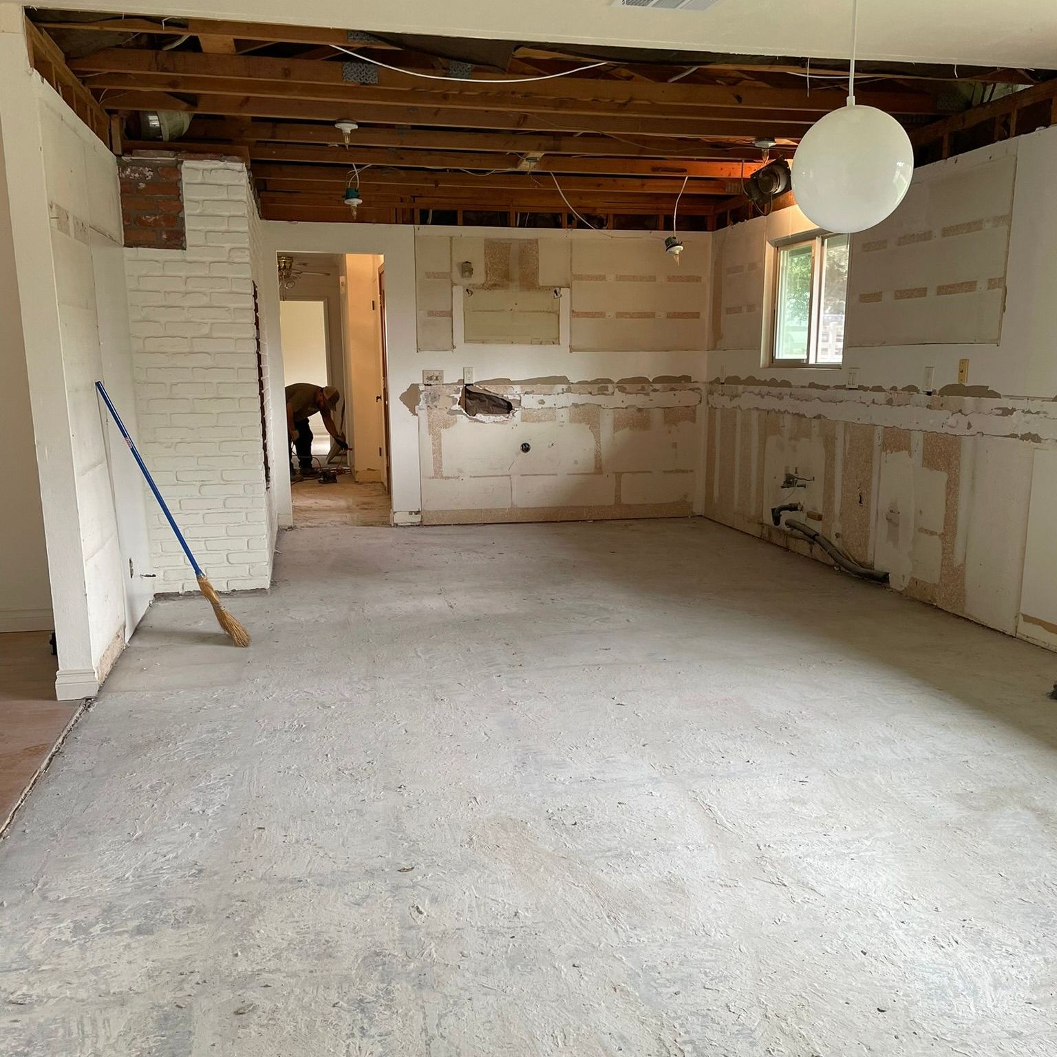 A room in an abandoned building with a lot of trash on the floor.