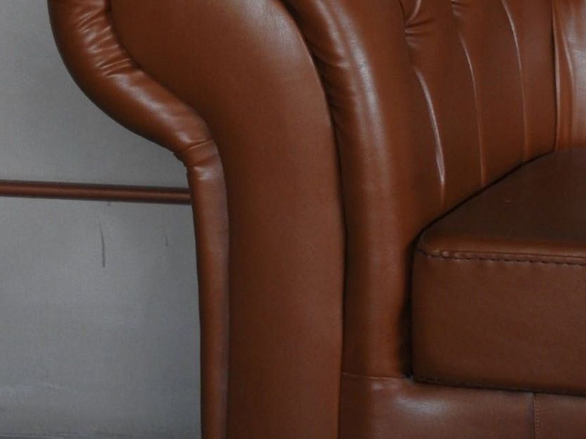 A brown leather chair is sitting in front of a wall