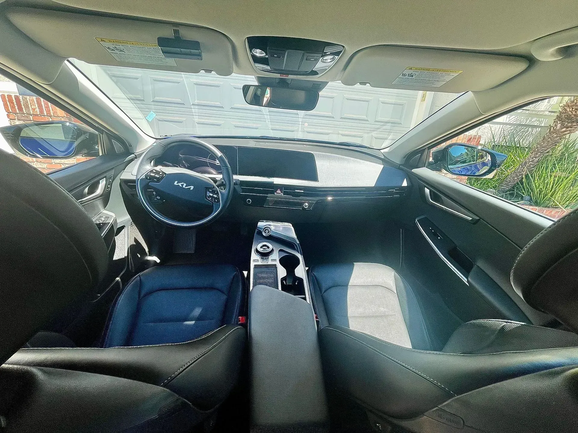 Interior view of a modern car cabin, featuring a steering wheel, center console, and front seats with dark upholstery.