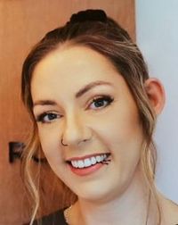 A woman with a nose ring is smiling for the camera.