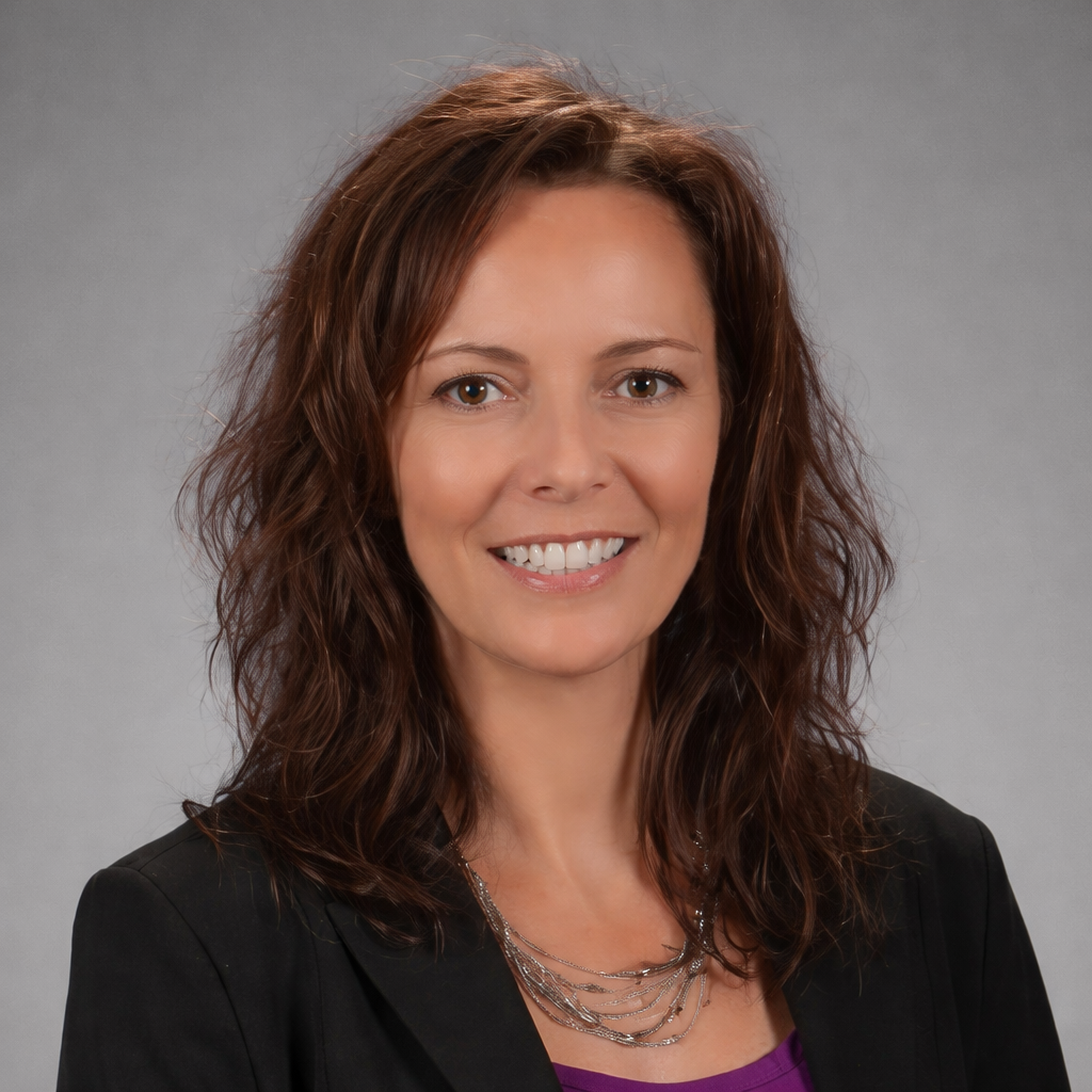 Woman with brown hair smiles, wearing a black cardigan, white top, and beaded necklace. Gray background.