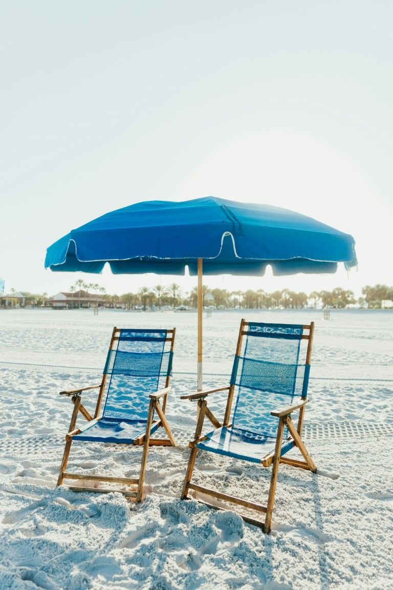 Pair of chairs beneath an umbrella on the beach