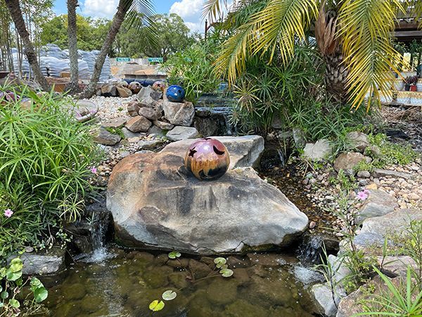 yard art sitting on a boulder creating a dual waterfall