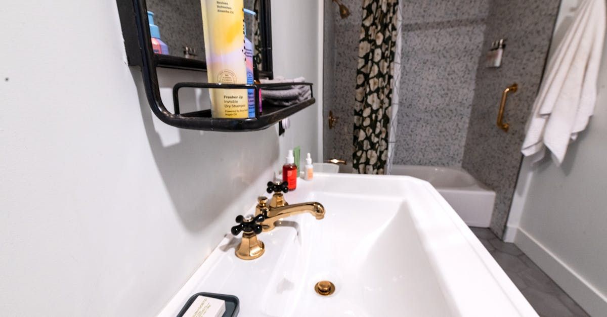 A bathroom with a sink , mirror and shower.