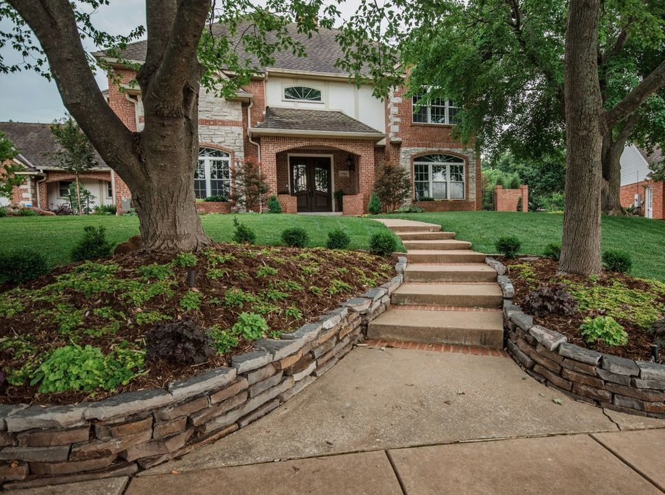 stairway to home with nice garden beds surrounding trees