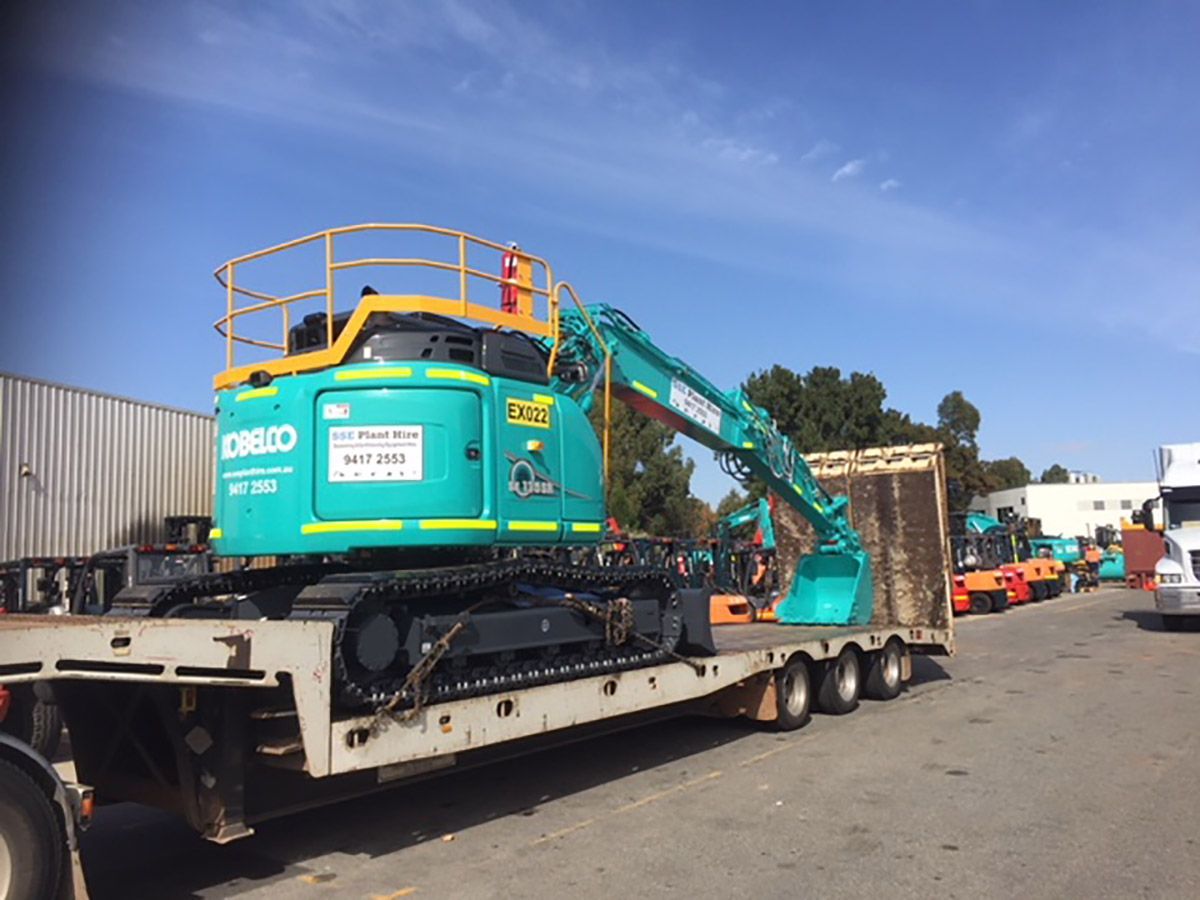 A large excavator is being transported on a trailer.