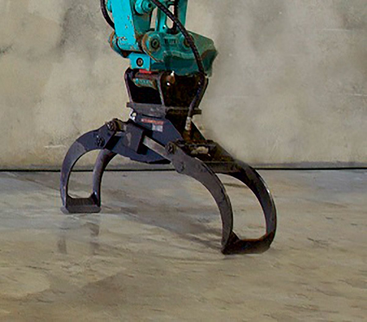 A blue and black machine is sitting on a concrete floor.