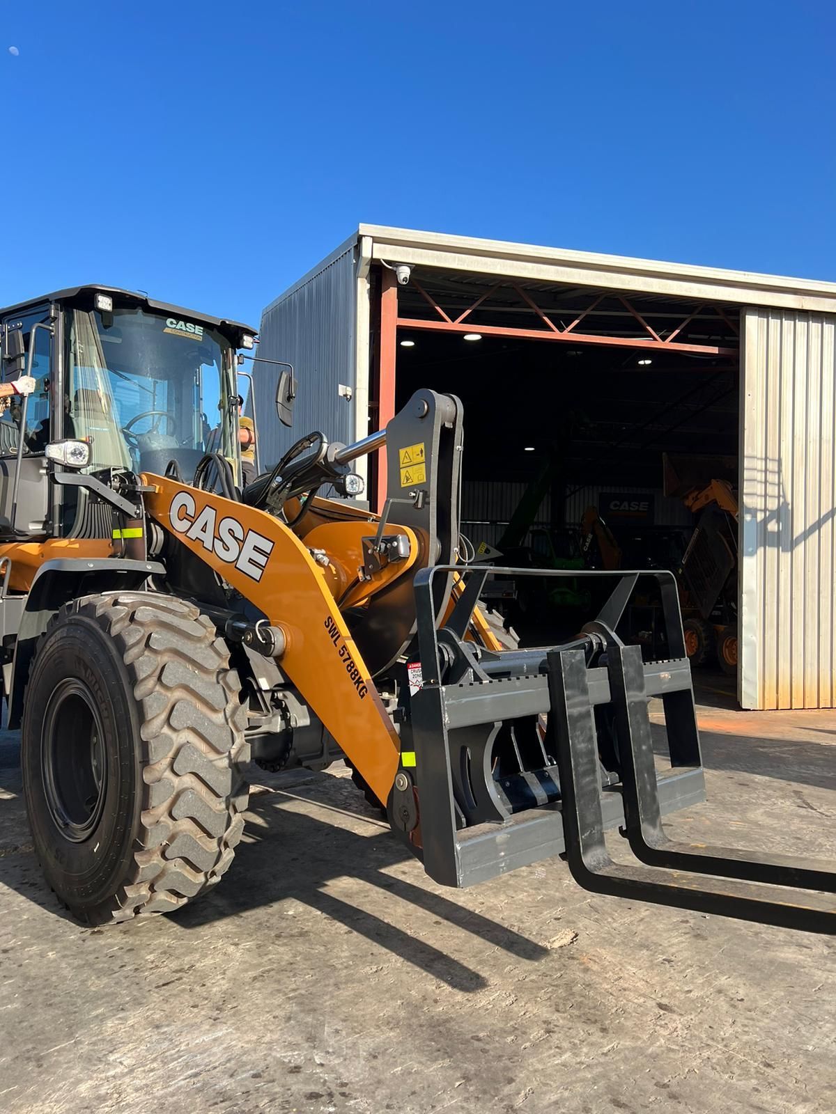 A case wheel loader is parked in front of a building.
