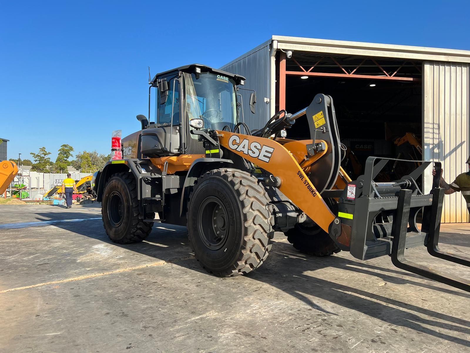 A case wheel loader is parked in front of a building.