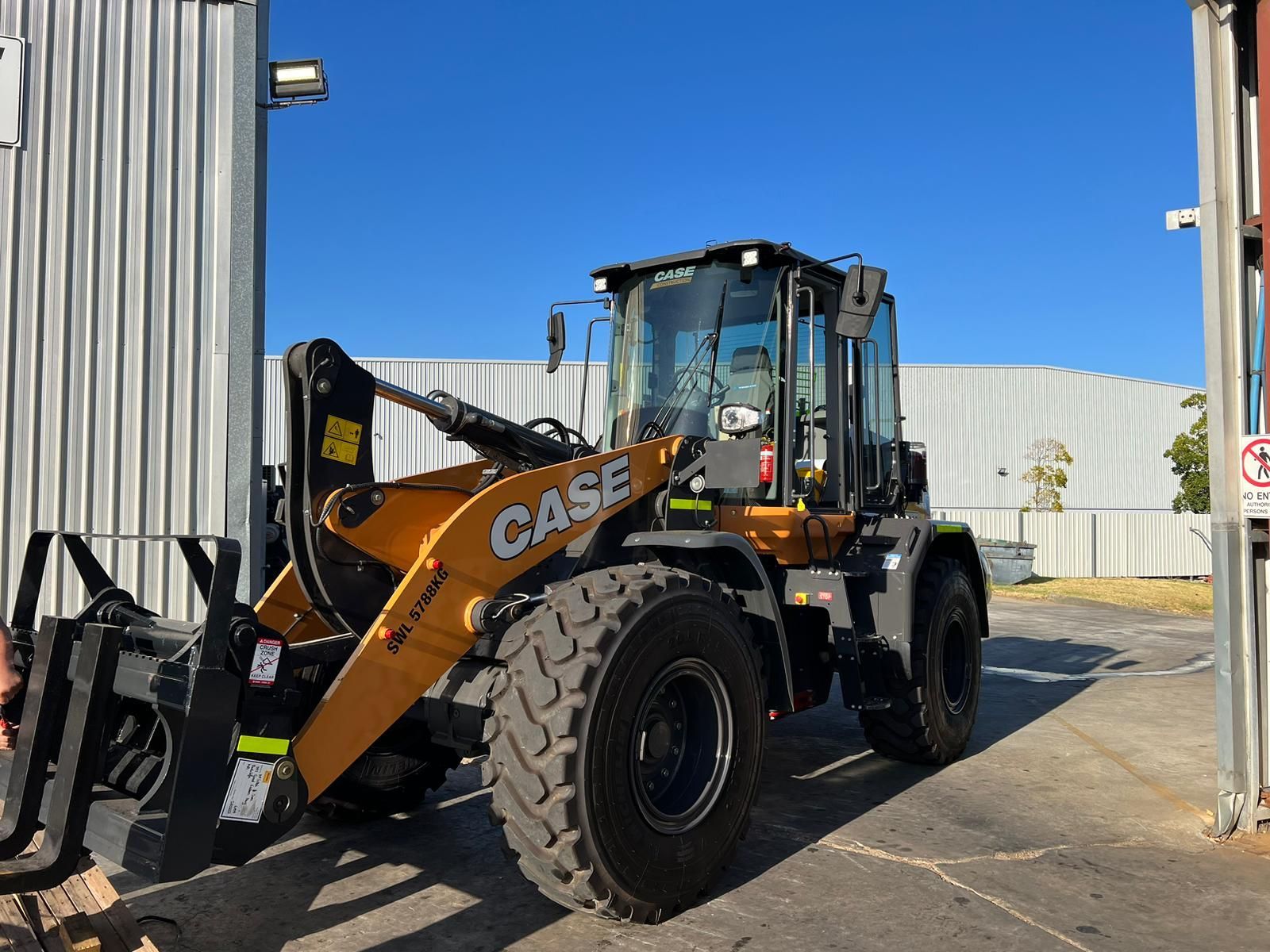 A case wheel loader is parked in front of a building.