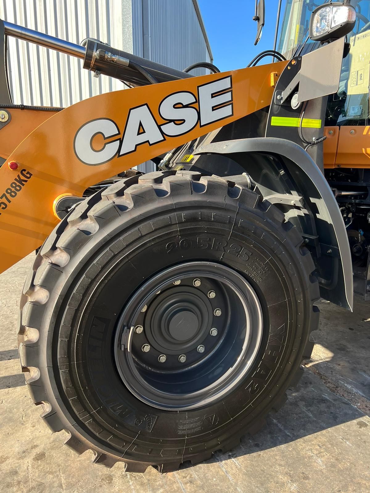 A case wheel loader is parked in front of a building.