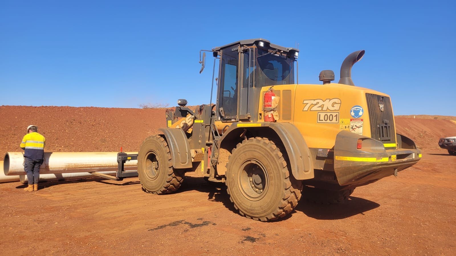 A yellow tractor with the number 725c on it