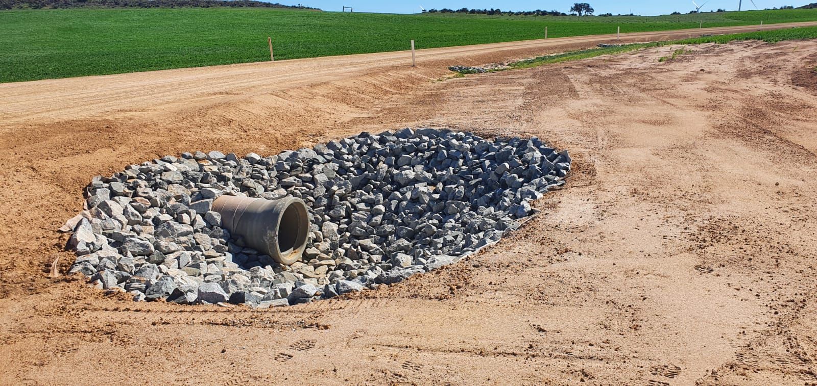 A pipe is sitting in the middle of a pile of rocks.
