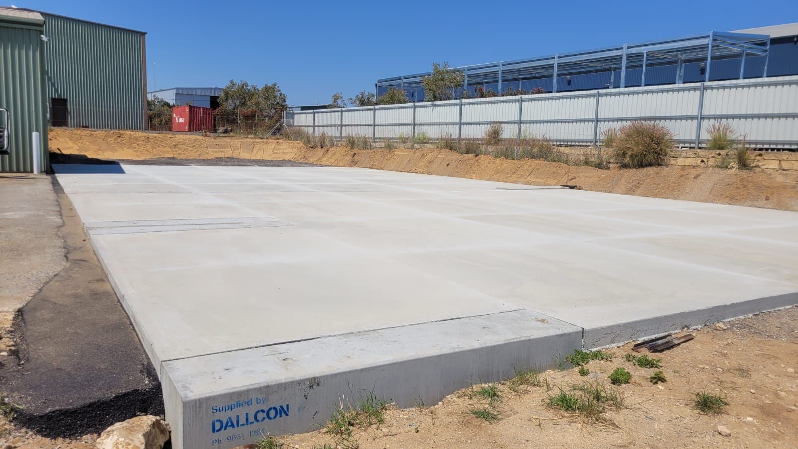 A large concrete slab is sitting in the middle of a dirt field.