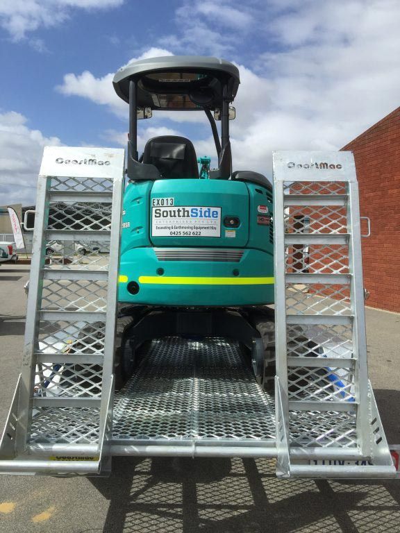 A small green excavator with a southside sign on the back