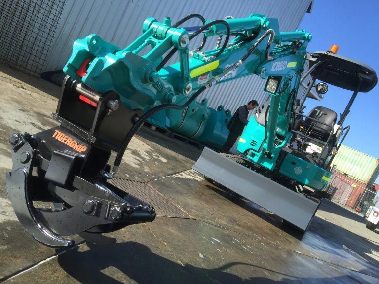 A blue excavator is parked in a parking lot
